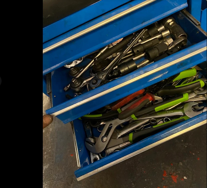 An open tool chest drawer of ratchets and wrenches
